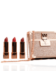 Luxury red lipstick trio with three velvety matte red shades and glittering gold clutch case with chain strap