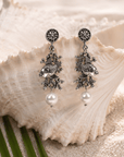 Paloma silver angelfish dangle earrings featuring sculpted fish, dimensional coral inspired detailing and luminous pearl drops.
