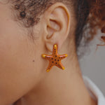 Caicos Studs- Starfish- Sassy Jones, orange resin earrings, starfish motif, gold hardware, wedding jewelry, Turks and Caicosbeaded jewelry, handcrafted, vibrant colors, intricate designs, timeless elegance, elegant earrings, glass beads, gemstones, natural elements, sophistication, special occasions, casual wear, thoughtful gifts, artistry, fashion, Handcrafted jewelry, Playful design, Elegant craftsmanship, Fashion accessory, birthday jewelry, wedding jewelry, bridal jewelry 