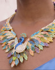 Sassy Jones peacock necklace shown on model featuring layered jewel toned feathers and gold tone finish.