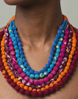 Close view of Kenza Cloth Bead Bib featuring saturated multicolor beads in mixed solid and patterned fabrics.