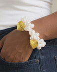Close up of Amora Pearl Heart Bracelet featuring luminous pearl clusters and embossed gold heart details.