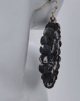Black and white fabric bead earrings with an open circular silhouette and gold colored hooks.