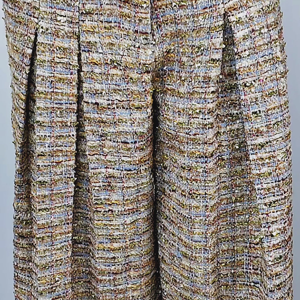 1. The Claire Tweed Trouser shown on model with high waist, tailored pleats, functional side pockets, and floor-length wide legs.