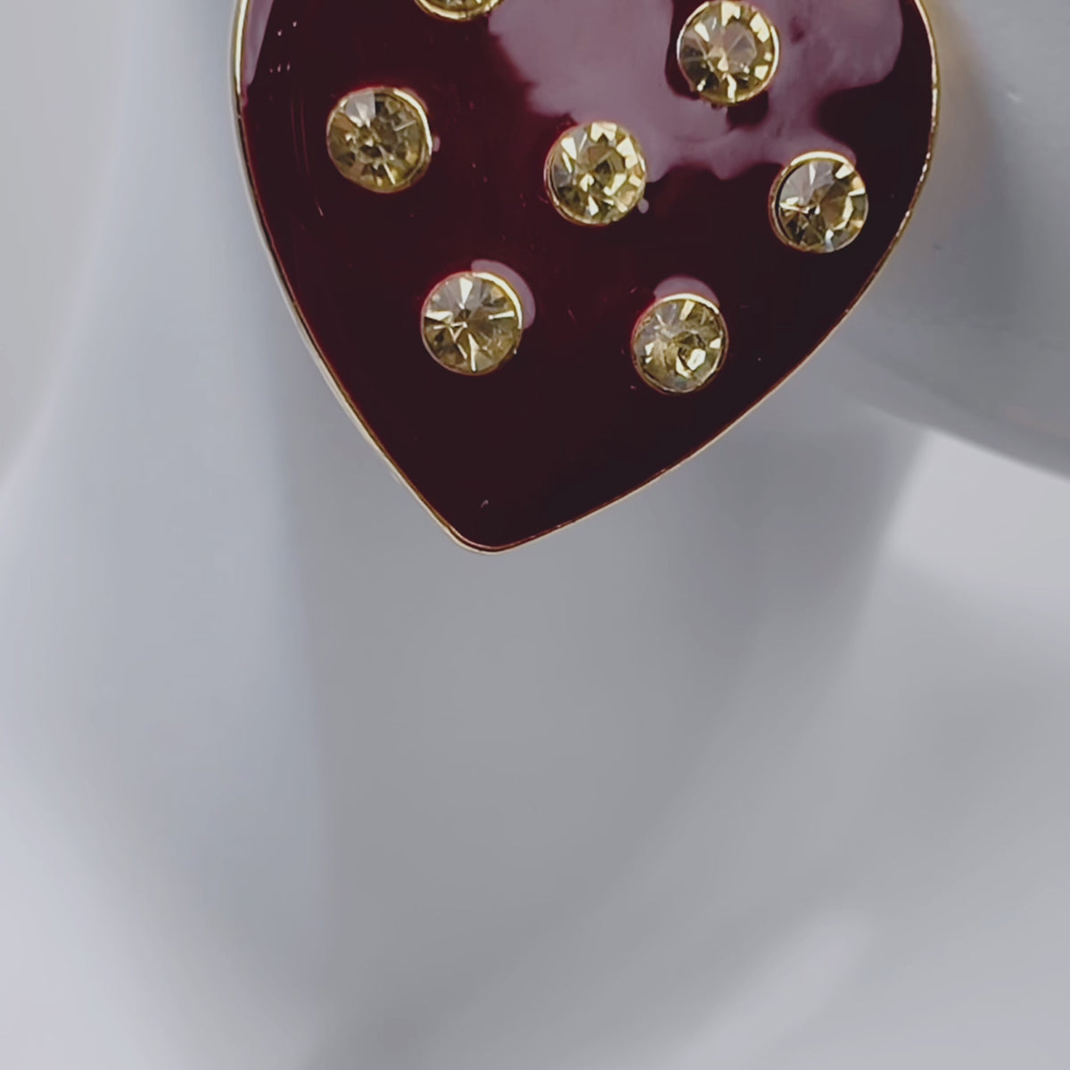 Oversized red heart stud earrings featuring a glossy crimson surface with clear crystals and 18K gold plated detailing.