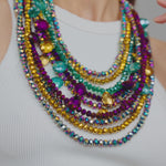 -9-strand design in iridescent purple, teal, and gold hues -4 lower strands are detachable for versatile wear -Hand-strung faceted glass AB beads  -Dangling larger glass pendants on 2 strands  -Collar length -Silver metal hardware 