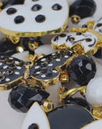 Close up of Sassy Jones Lovebug Brooch Bib with faceted black beads, white beads and removable decorative charms.