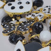 Close up of Sassy Jones Lovebug Brooch Bib with faceted black beads, white beads and removable decorative charms.