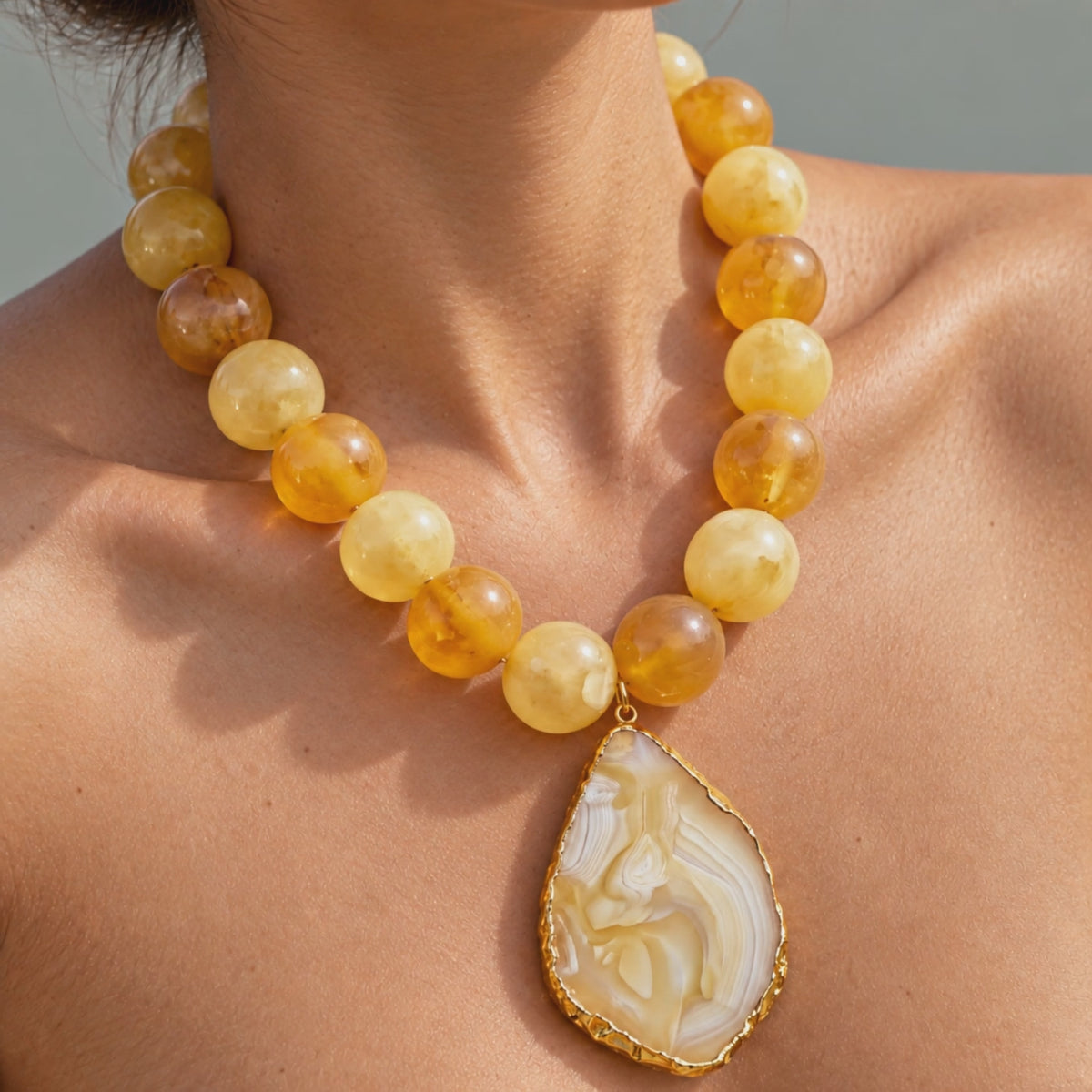 Close-up of Chrysallis Lemon Sorbet Necklace featuring a natural agate slice edged in a Gold tone finish.