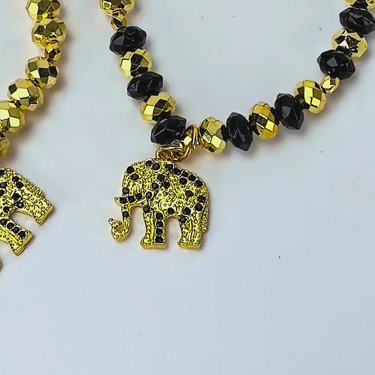 Close up of four coordinating Ibiza stretch bracelets with mixed black and gold faceted beadwork.
