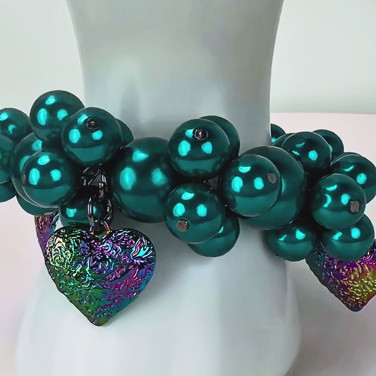 Rainbow Teal Amora bracelet with glossy teal pearl beads and colorful textured heart pendants.