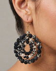 Black and white fabric bead earrings with an open circular silhouette and gold colored hooks.