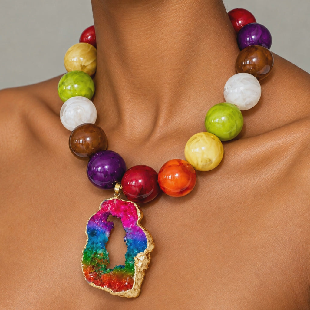 Rainbow statement jewelry featuring a raw sliced agate pendant and vibrant jewel toned beads.