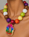 Rainbow statement jewelry featuring a raw sliced agate pendant and vibrant jewel toned beads.