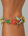 Close up of Cherish Hummingbird Bracelet highlighting blue wing detailing, sparkling crystal accents and colorful enamel flowers.