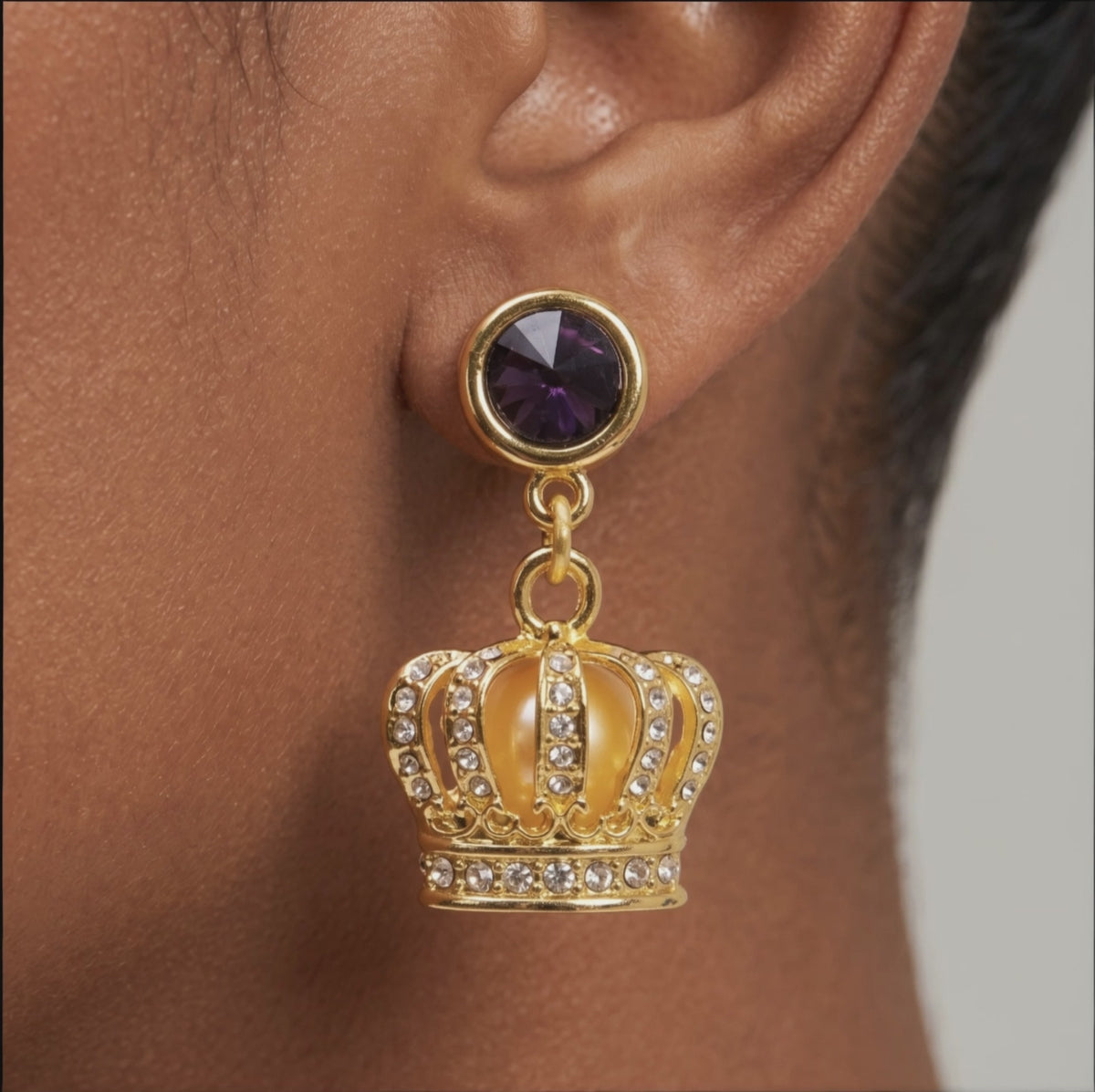 Sassy Jones Reign Pavé Crown Earrings featuring purple accents, champagne centers and ornate gold detailing.