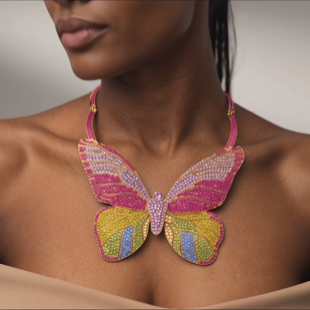 Statement butterfly bib necklace featuring vibrant multicolored crystals in coral, pink, gold, turquoise, and emerald with gold tone detailing.