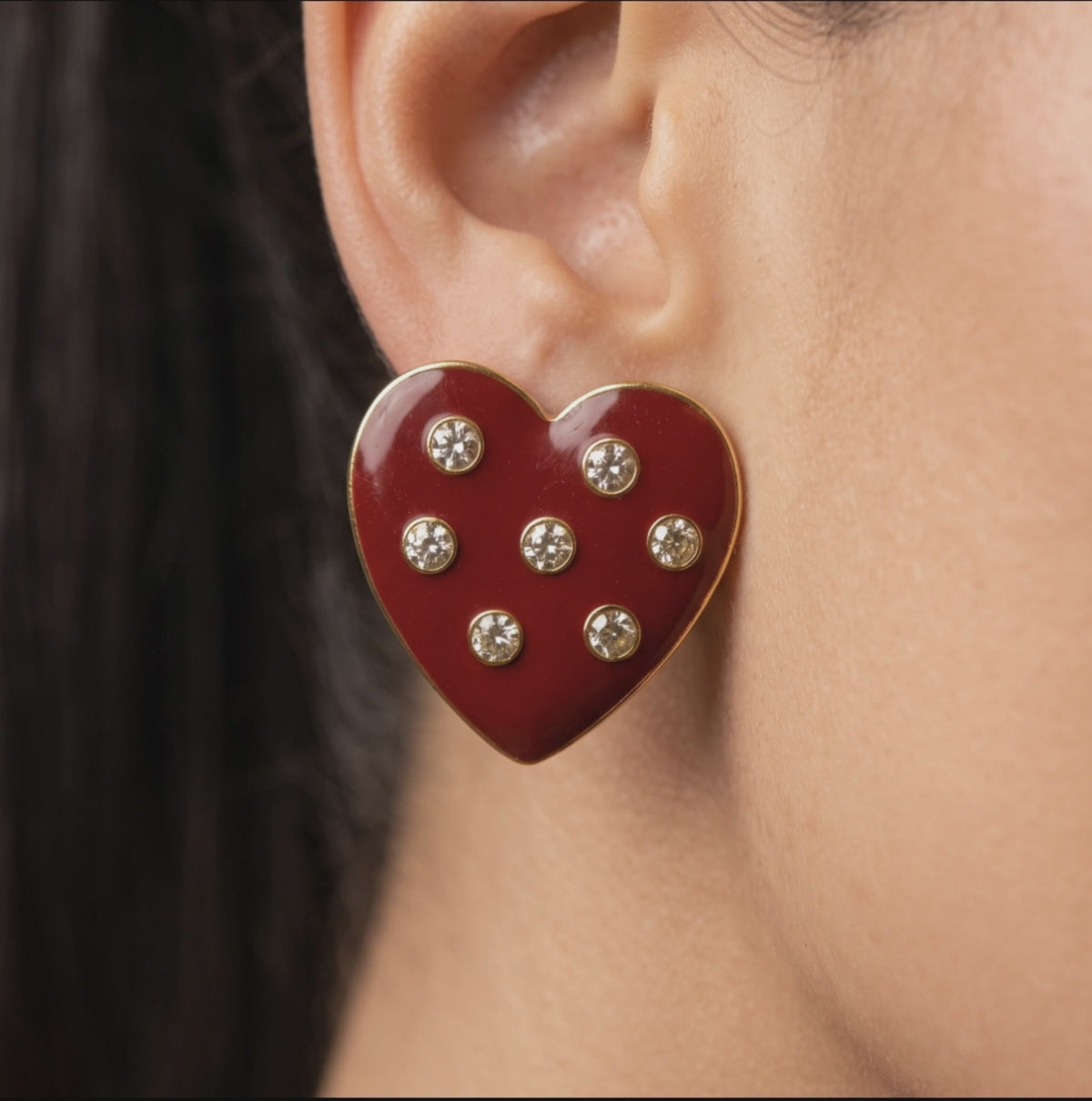 Oversized red heart stud earrings featuring a glossy crimson surface with clear crystals and 18K gold plated detailing.