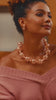 Close-up of sculptural rose gold necklace featuring alternating large openwork globes and petite textured beads.