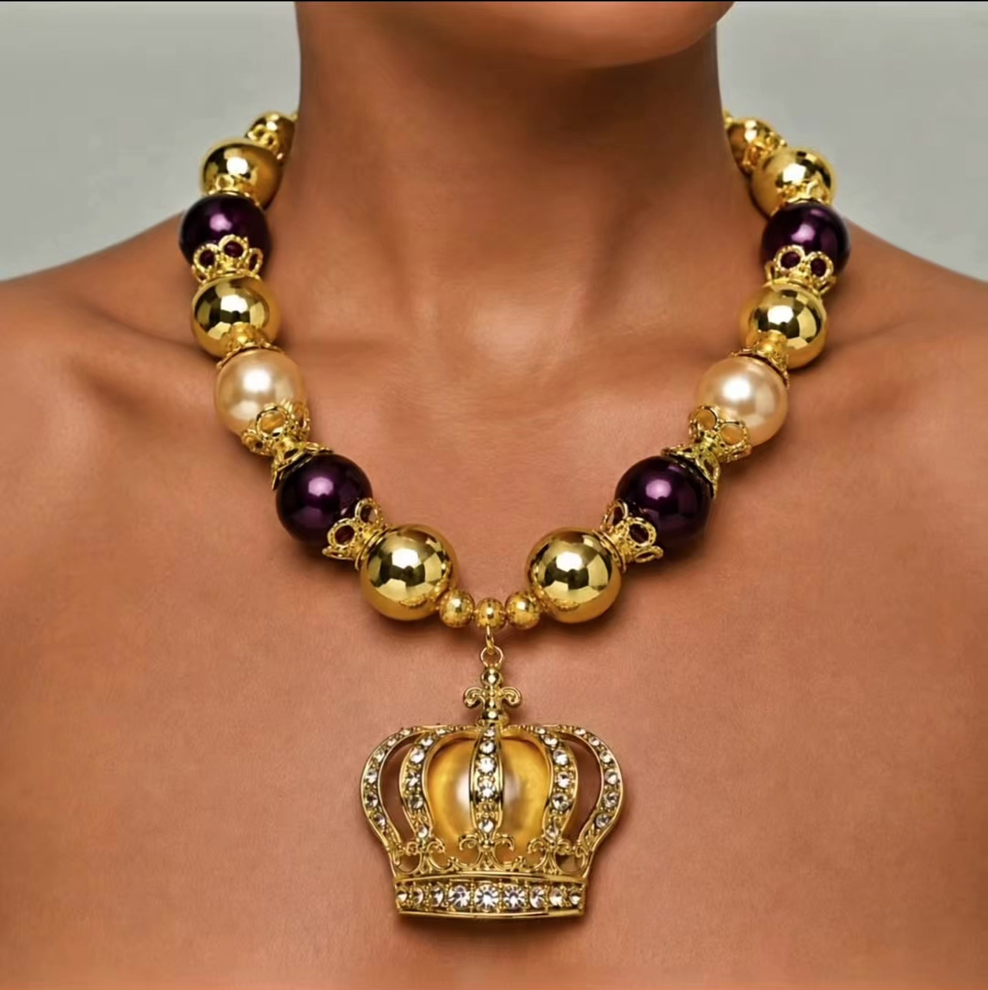 Sassy Jones Reign necklace with champagne pearl beads, metallic gold beads and crystal embellished crown pendant.