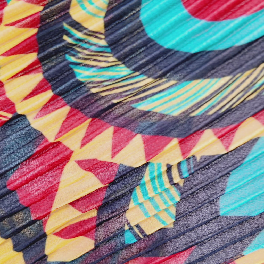 Woman wearing the Imani Afrikaan maxi dress with dramatic pleated sleeves, collared neckline, and flowing printed skirt.