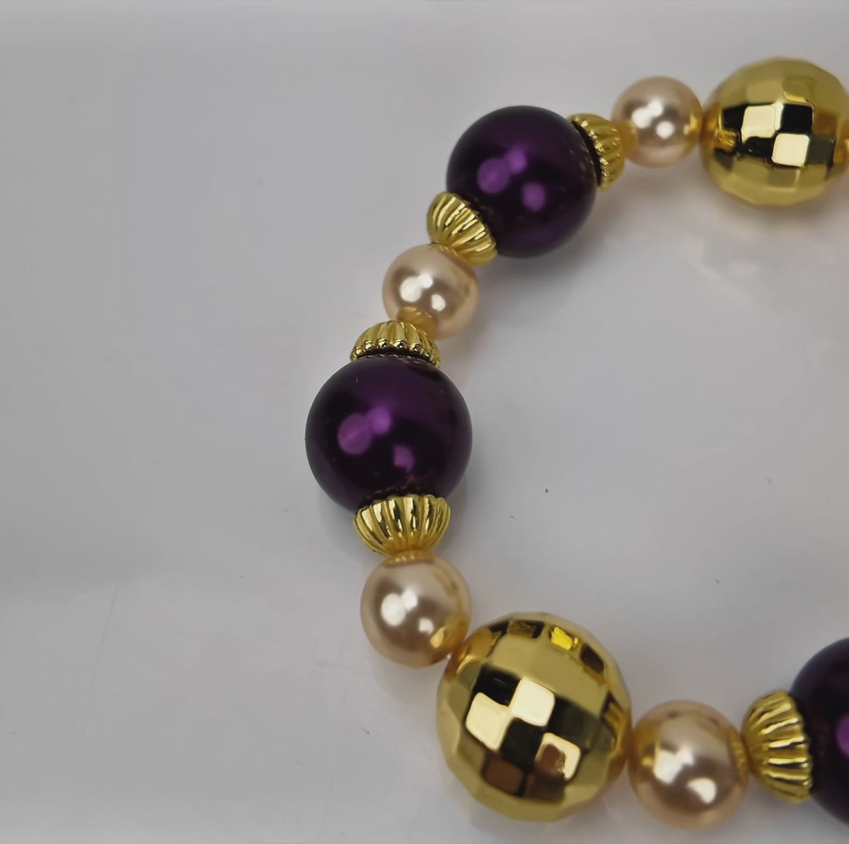  Sassy Jones Reign three-piece bracelet stack featuring champagne pearls, purple beads and 18K gold plated details.