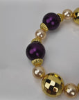  Sassy Jones Reign three-piece bracelet stack featuring champagne pearls, purple beads and 18K gold plated details.