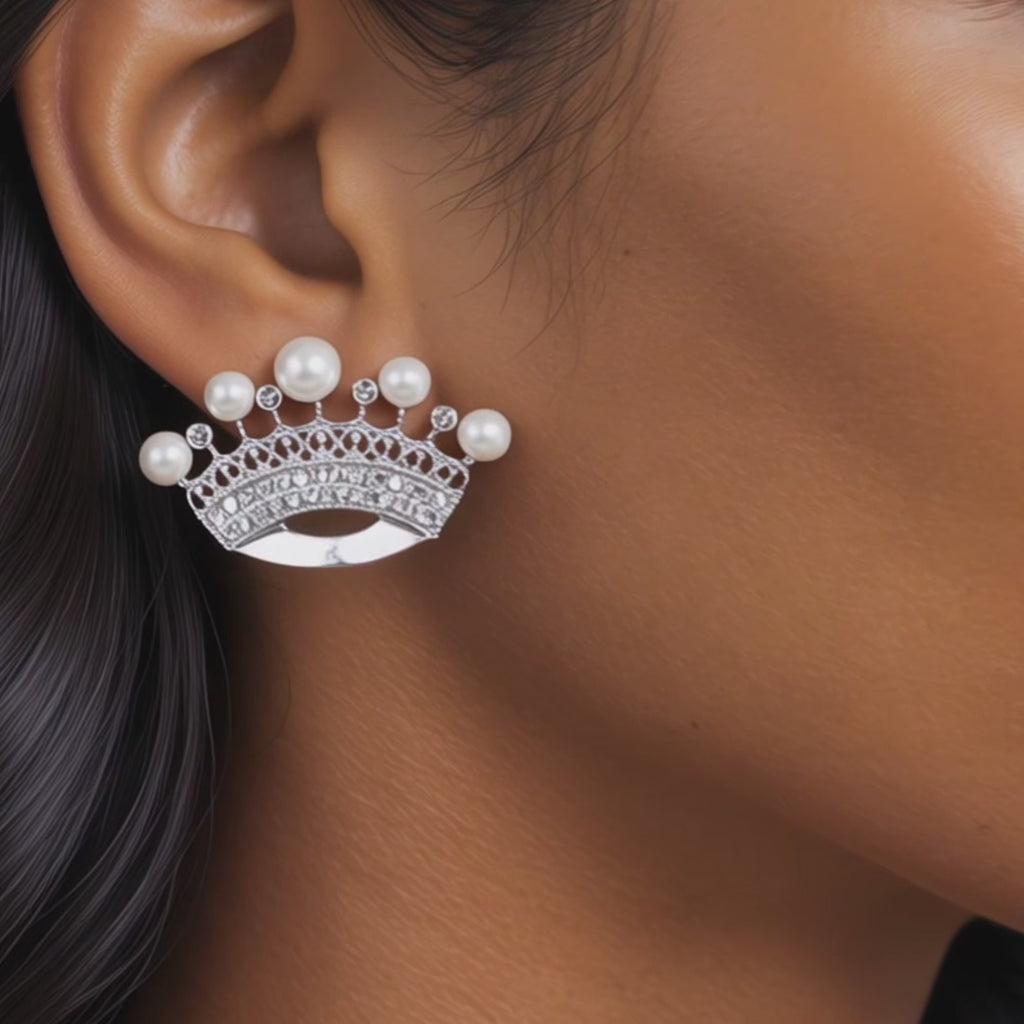 Close up of Valerie Pearl Queen earrings showcasing intricate openwork crown silhouettes and round ivory pearls.