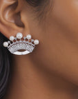 Close up of Valerie Pearl Queen earrings showcasing intricate openwork crown silhouettes and round ivory pearls.