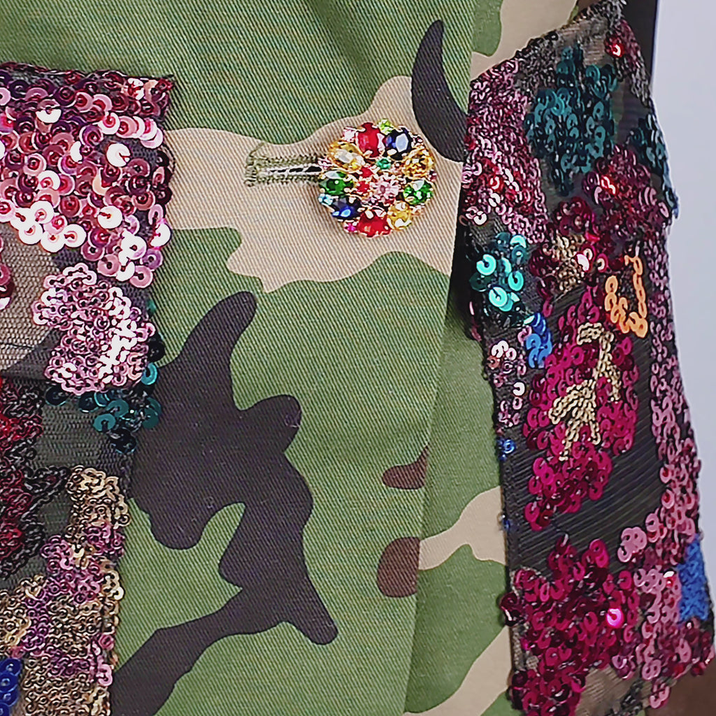 Women's hooded statement blazer featuring green camouflage, multicolor sequins and decorative jeweled cuff buttons.