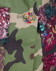 Women's hooded statement blazer featuring green camouflage, multicolor sequins and decorative jeweled cuff buttons.