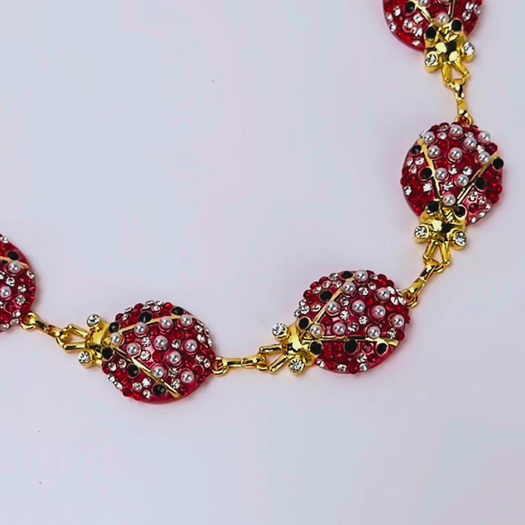 Red ladybug statement chain featuring sparkling crystals, pearl-like accents and Gold tone finish details.