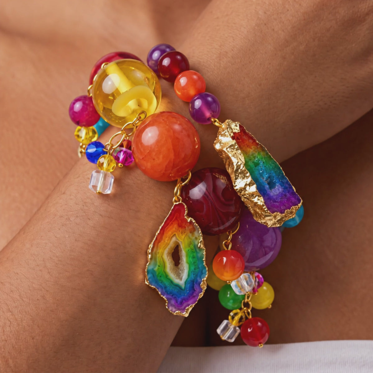 Chrysallis Joyride stretch bracelets featuring a large rainbow agate centerpiece and colorful dangling bead clusters.