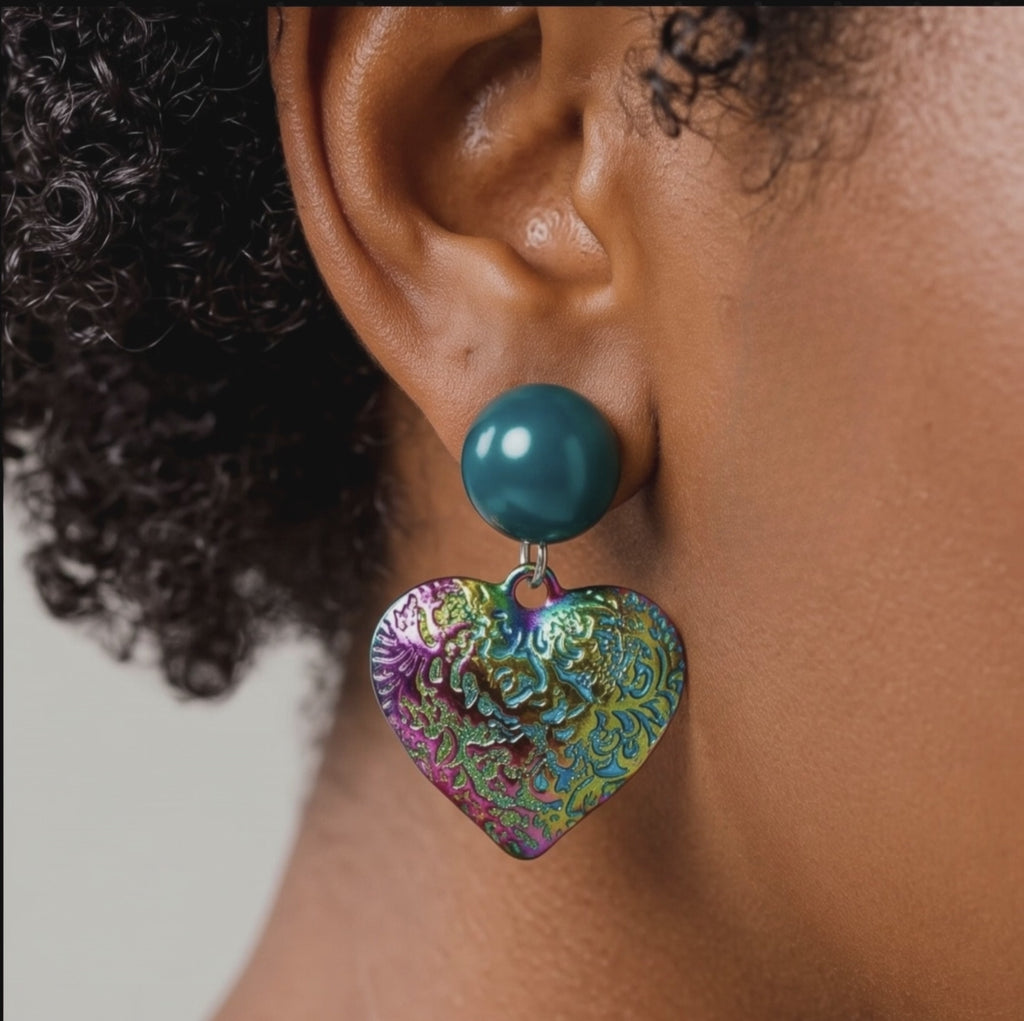 Colorful heart statement earrings with glossy teal glass pearl studs and textured iridescent rainbow drops.