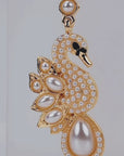 Elegant gold tone swan earrings designed with crystal covered bodies, layered pearl wings, and dangling teardrop pearls.