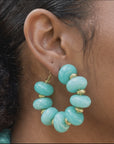 Kamaria Coconut Shell Statement Hoops in Riviera Teal featuring oversized marbled teal coconut shell pieces and gold accents.