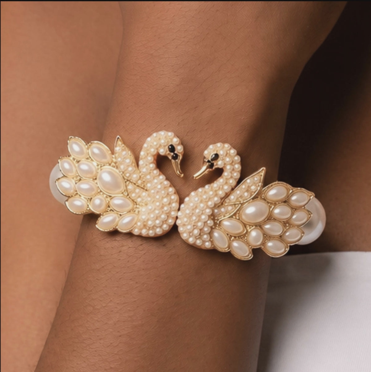 Luxury pearl bracelet featuring two jeweled swans with sparkling crystal bodies and dimensional pearl feather detailing