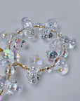 Close up of Alana Cloud Bubble Hoops showing translucent clustered bubbles with a rainbow reflective finish.