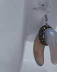 Zuma crescent dangle earrings featuring organic shell variation, crystal detailing, and delicate hook ear wires.