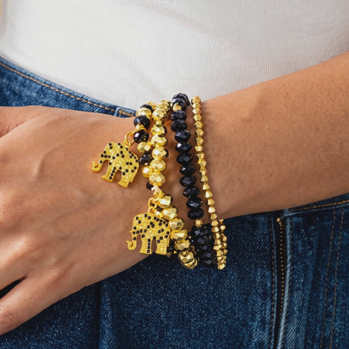 Close up of four coordinating Ibiza stretch bracelets with mixed black and gold faceted beadwork.