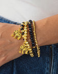 Close up of four coordinating Ibiza stretch bracelets with mixed black and gold faceted beadwork.