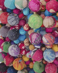 Colorful textile statement handbag with dimensional cloth bead construction and matching embellished handles.