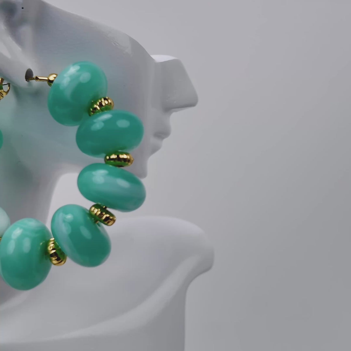 Kamaria Coconut Shell Statement Hoops in Riviera Teal featuring oversized marbled teal coconut shell pieces and gold accents.