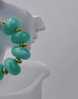 Kamaria Coconut Shell Statement Hoops in Riviera Teal featuring oversized marbled teal coconut shell pieces and gold accents.