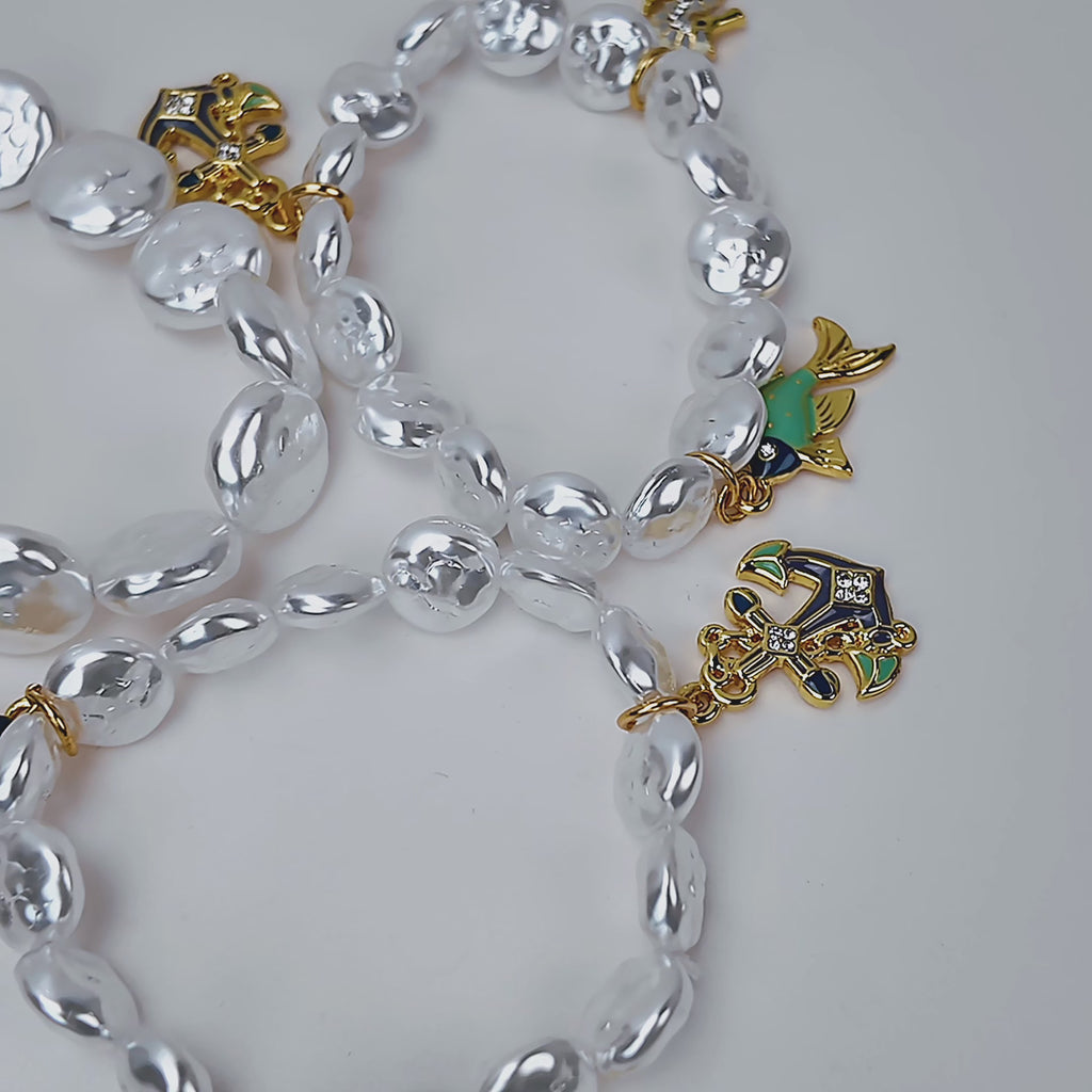 Harbor Grace bracelet stack featuring irregular luminous pearls with sculptural seahorse and ocean inspired charms.