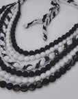 Close view of Kenza Cloth Bead Bib featuring mixed black and white textile covered beads.