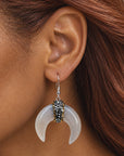 Zuma crescent dangle earrings featuring organic shell variation, crystal detailing, and delicate hook ear wires.