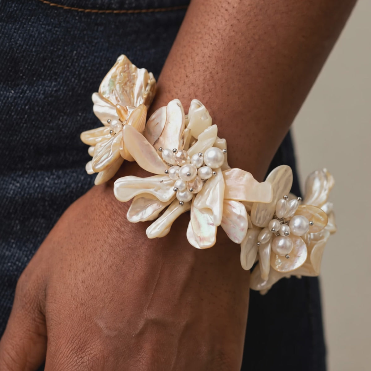 Ivory floral bracelet featuring dimensional natural shell blossoms, luminous pearls and intricate handcrafted detailing.