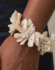 Ivory floral bracelet featuring dimensional natural shell blossoms, luminous pearls and intricate handcrafted detailing.