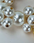 Close up of Amora Pearl Heart Bracelet featuring luminous pearl clusters and embossed gold heart details.